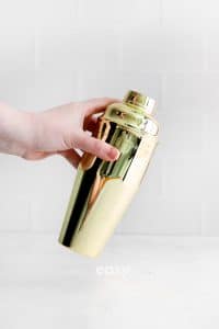 hand holding gold cocktail shaker