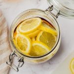 sliced lemons in clear jar with some brown honey