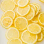 lots of lemon slices on white cutting board