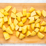 yellow diced potato cubes on wooden cutting board