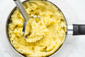 mashed potatoes with almond milk in pot with masher