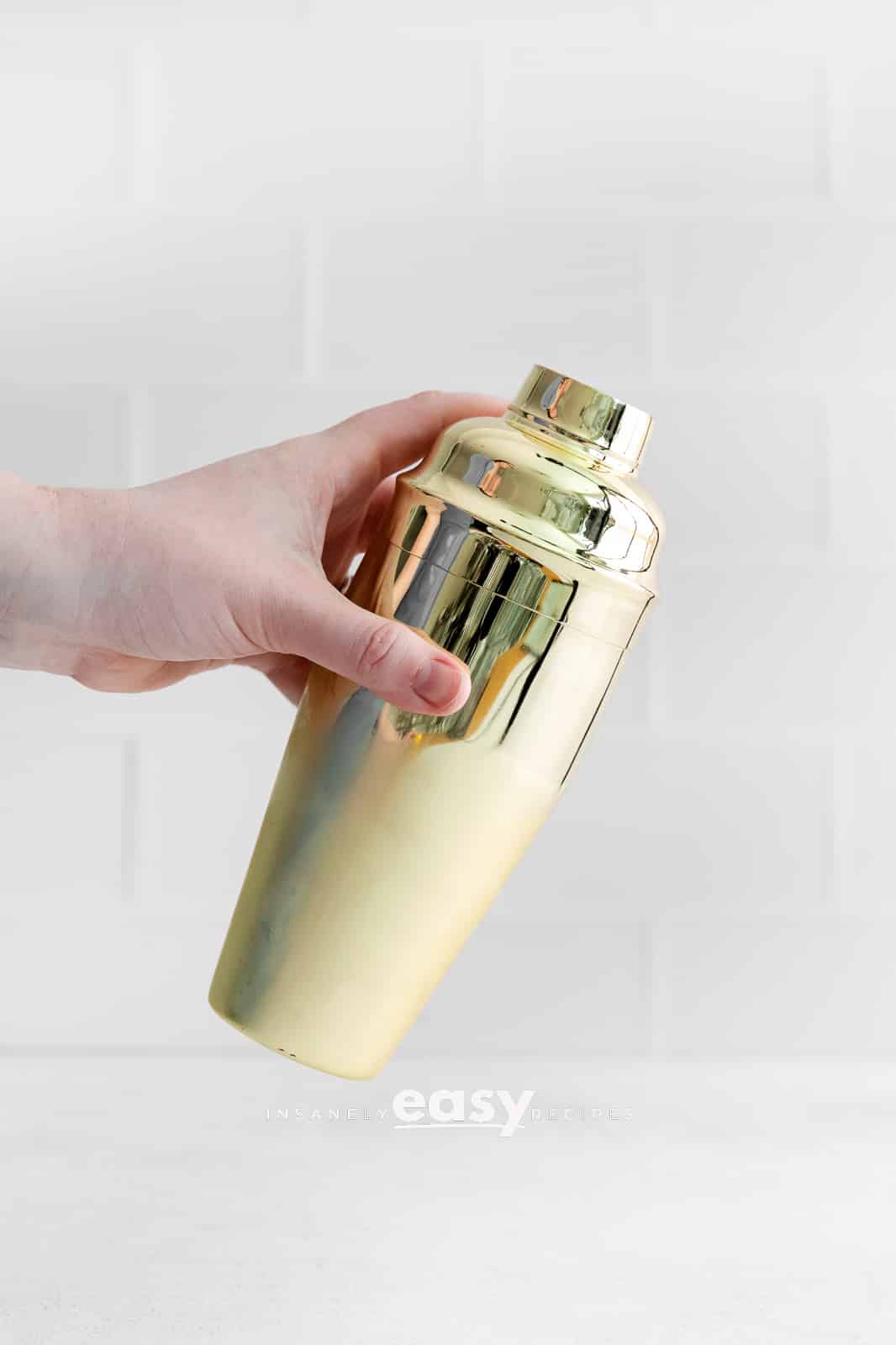 hand holding golden drink shaker