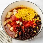 pot with liquid, potatoes, corn, black beans, tomatoes