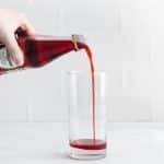 red liquid being poured into a glass