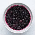 top view image of jammy blueberries in a white bowl for blueberry toast recipe