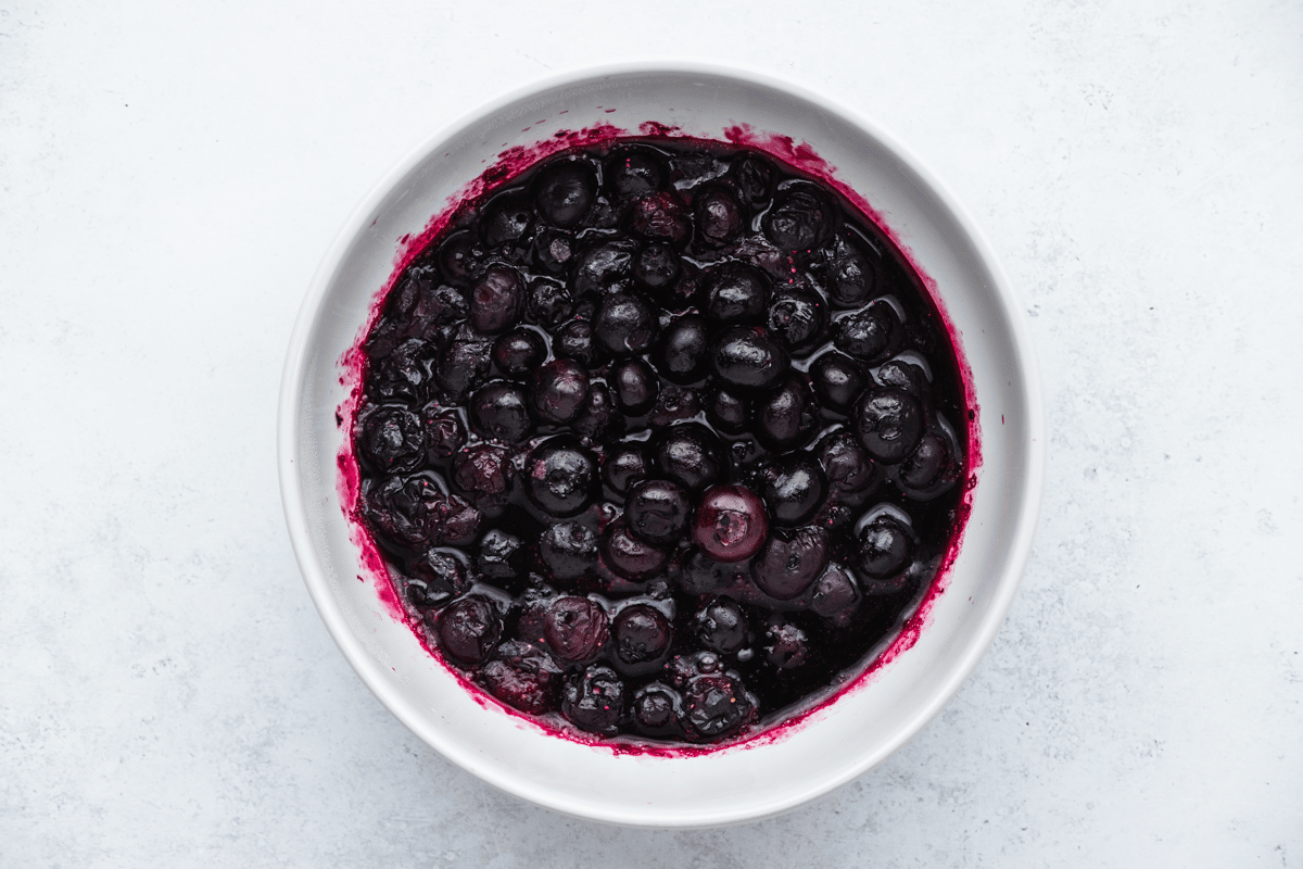 top view image of jammy blueberries in a white bowl for blueberry toast recipe