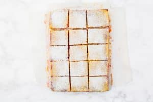 top view photo of sliced cranberry lemon bars with powdered sugar on top