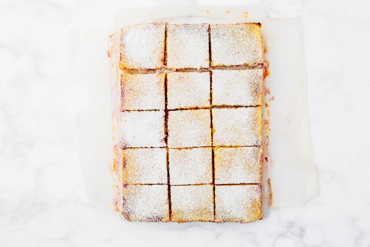 top view photo of sliced cranberry lemon bars with powdered sugar on top