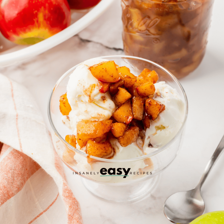 white ice cream in a glass jar with brown apple diced on top