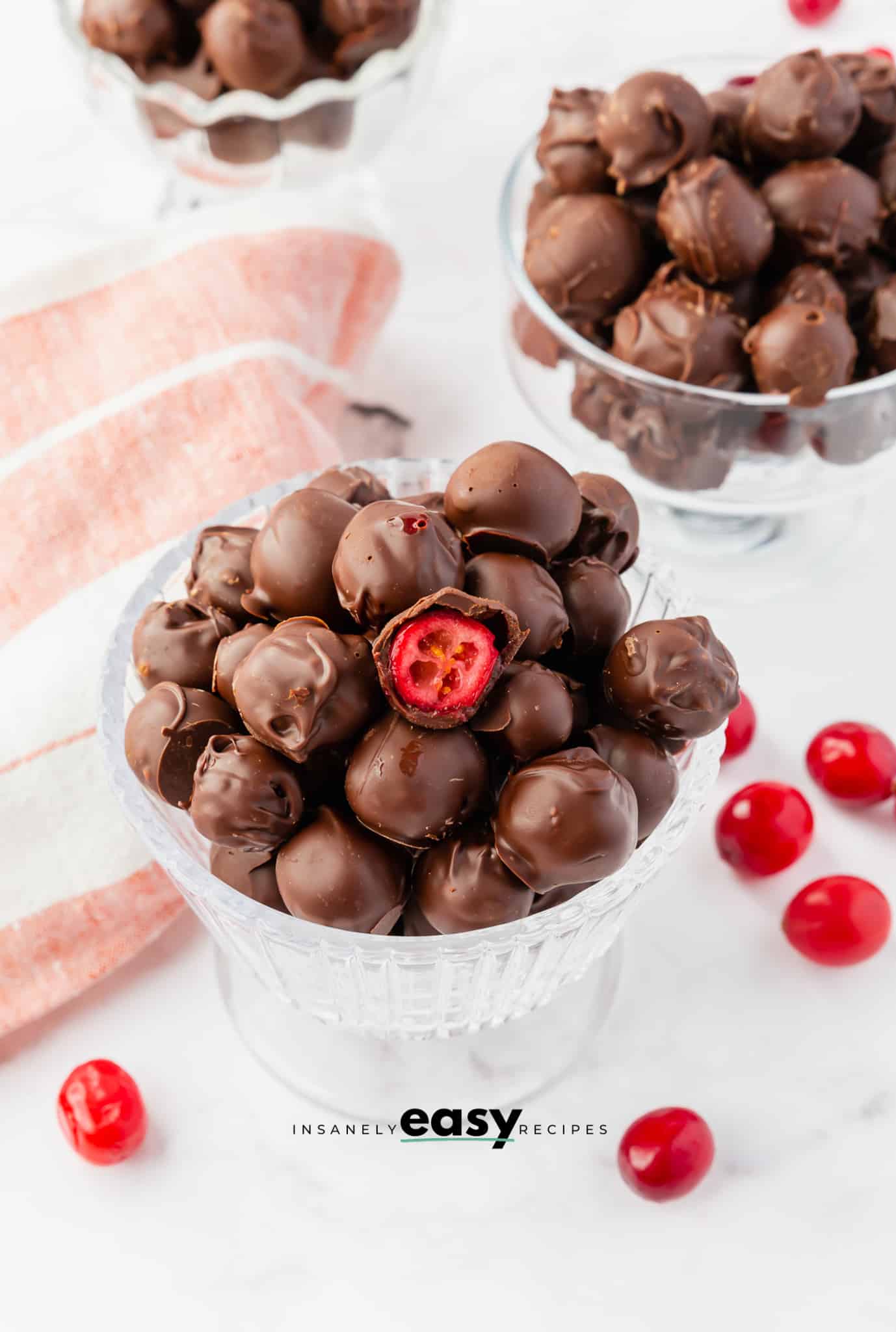 a footed dessert dish filled with chocolate covered fresh cranberries.