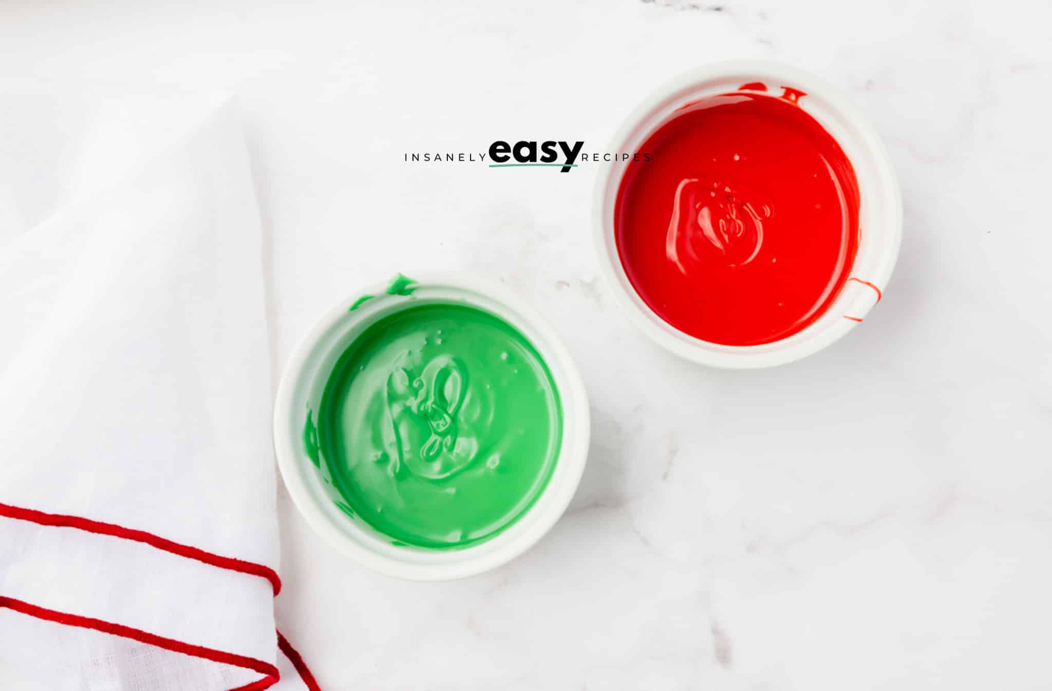 melted red and green frosting in white bowls