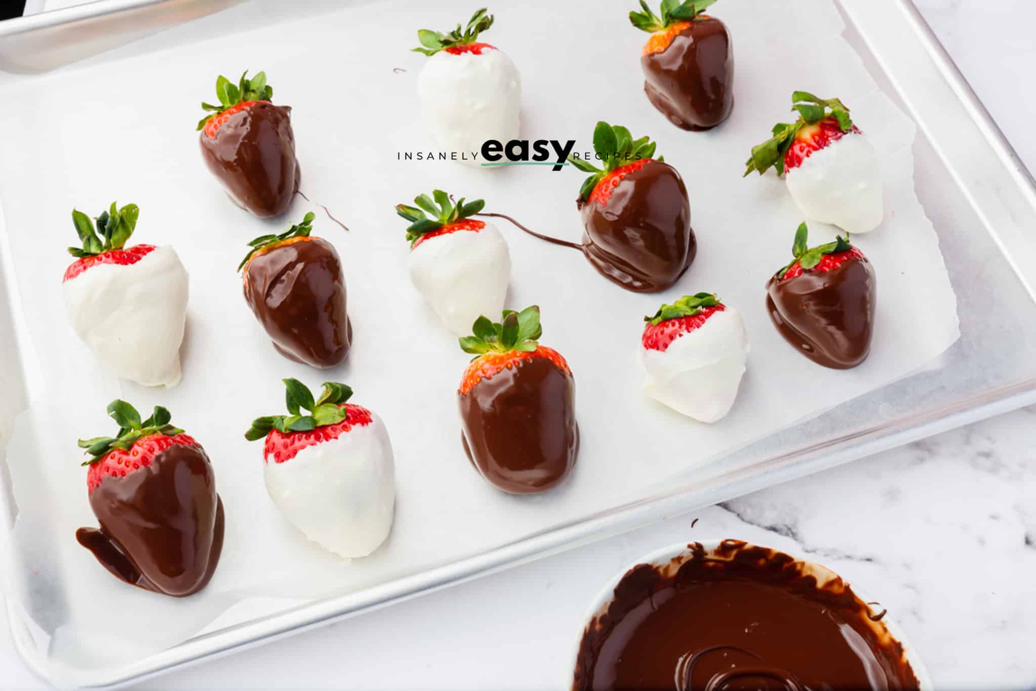 strawberries that have been dipped in white and brown chocolate on a white plate