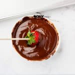 melted chocolate bowl with strawberry being dipped in