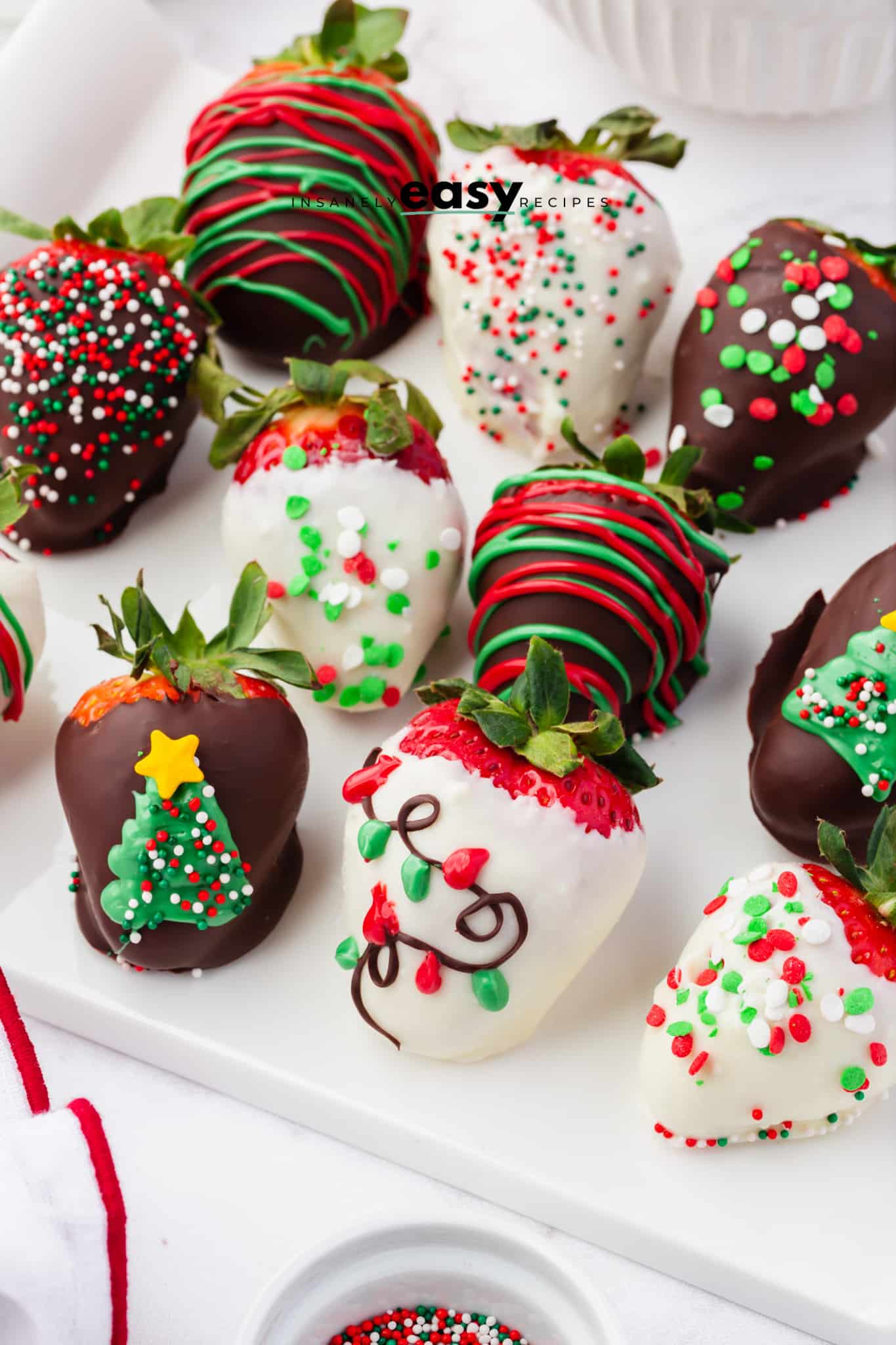 decorated christmas chocolate covered strawberries on a white plate