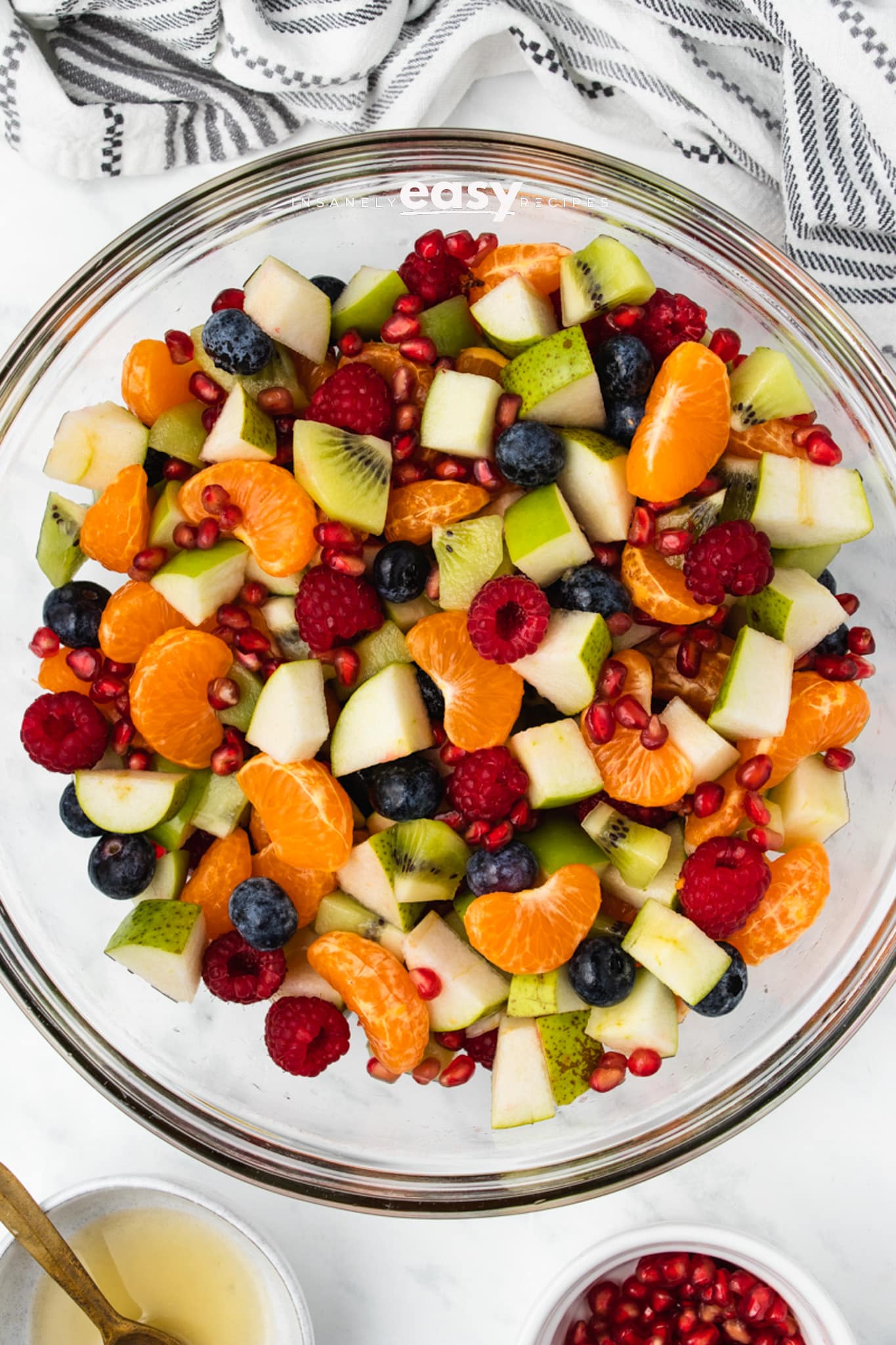 clear glass bowl of christmas fruit salad with napkin to top 