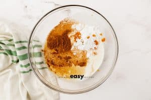 clear bowl with brown, yellow, orange and white powder in it