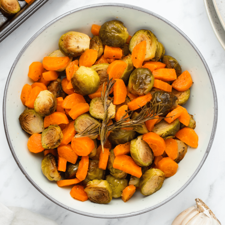 roasted brussel sprouts and carrots in a white bowl