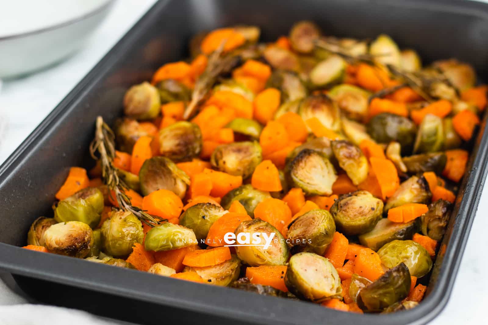 roasted brussel sprouts and carrots in a silver bakng pan