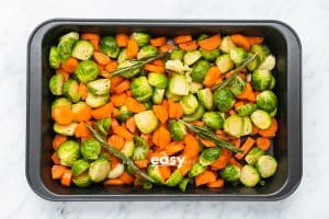uncooked brussels and carrots i a baking pan