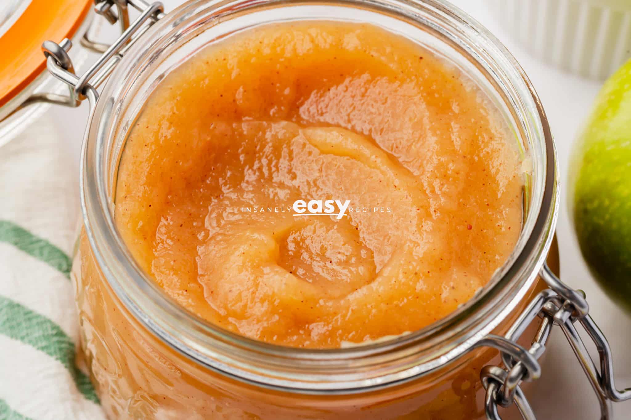 cooked puree of unsweetened applesauce in a glass container, an up close shot