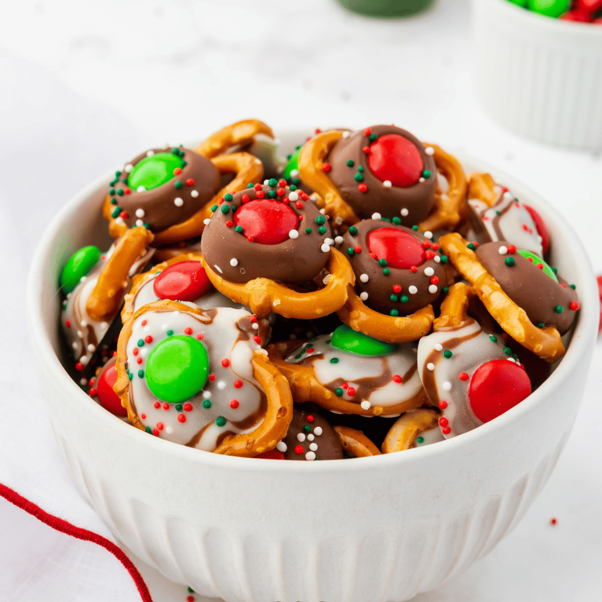a white bowl filled with christmas pretzels.