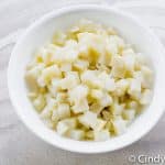 a white bowl filled with cooked cubed potatoes
