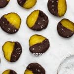 closeup photo of chocolate covered pickles with a bowl of flaky salt in the bottom right of the photo