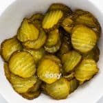 closeup photo of sliced pickles in a white bowl