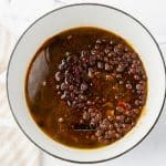 Black beans and broth stirred with seasonings to make chipotle seasoned black beans.