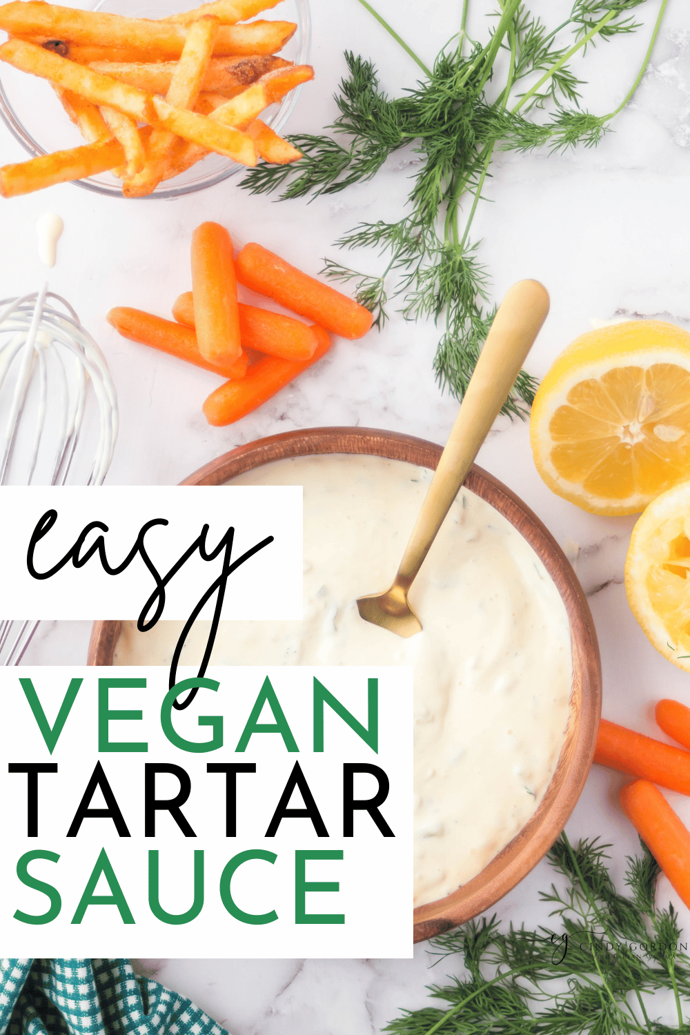 pinterest photo of vegan tarter sauce with carrots, lemons, dill, and a whisk in the photo surrounding the tarter sauce, in a wood bowl