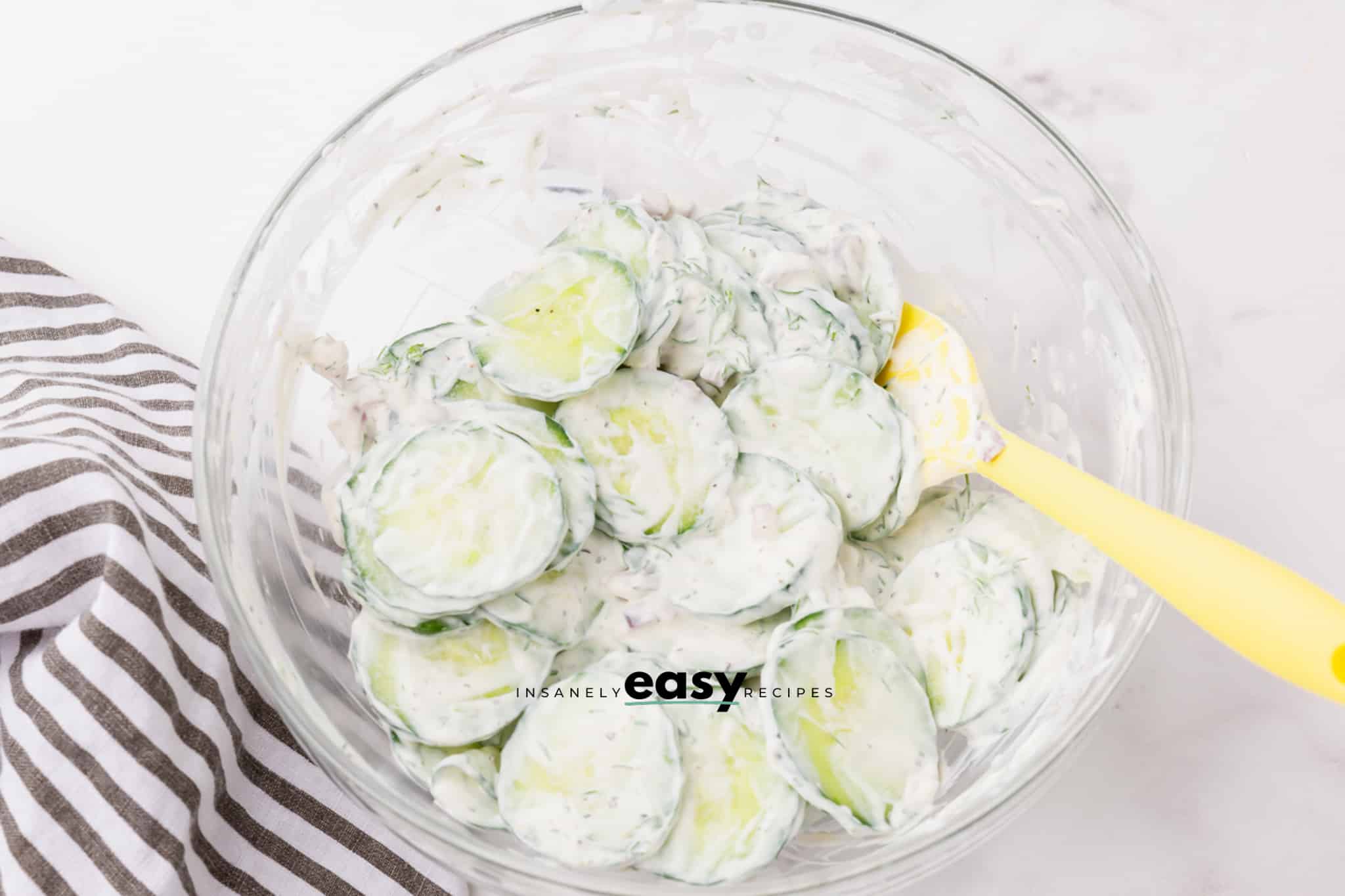 Sliced cucumbers dressed in sour cream for polish cucumber salad.