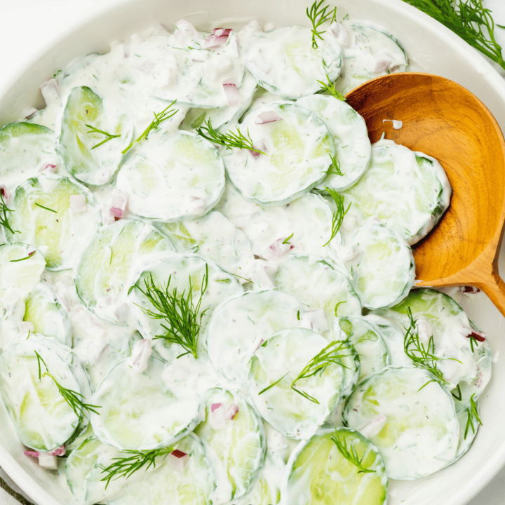 polish cucumber salad in a serving bowl with a large spoon.