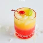 layered malibu rum sunrise drink with a cherry and lime garnish