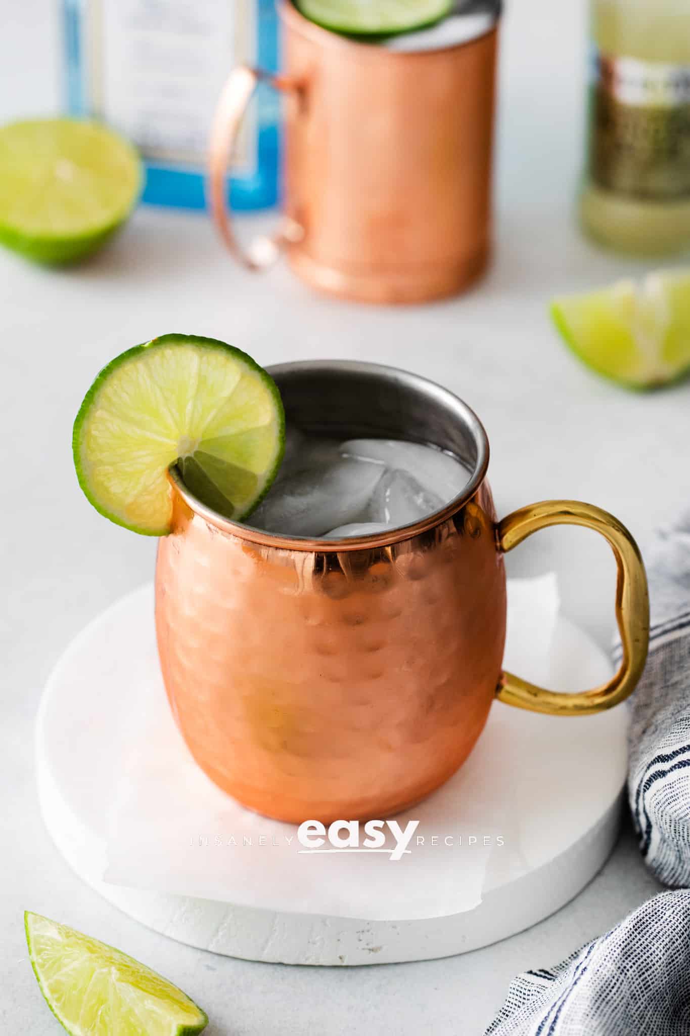 Photo of a London Mule cocktail in a copper mug with a lime round on the rim of the mug.