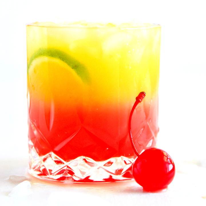 a rocks glass with a red and yellow layered malibu sunrise drink.