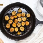 Top view photo of bananas in a cast iron skillet, caramelizing in butter.