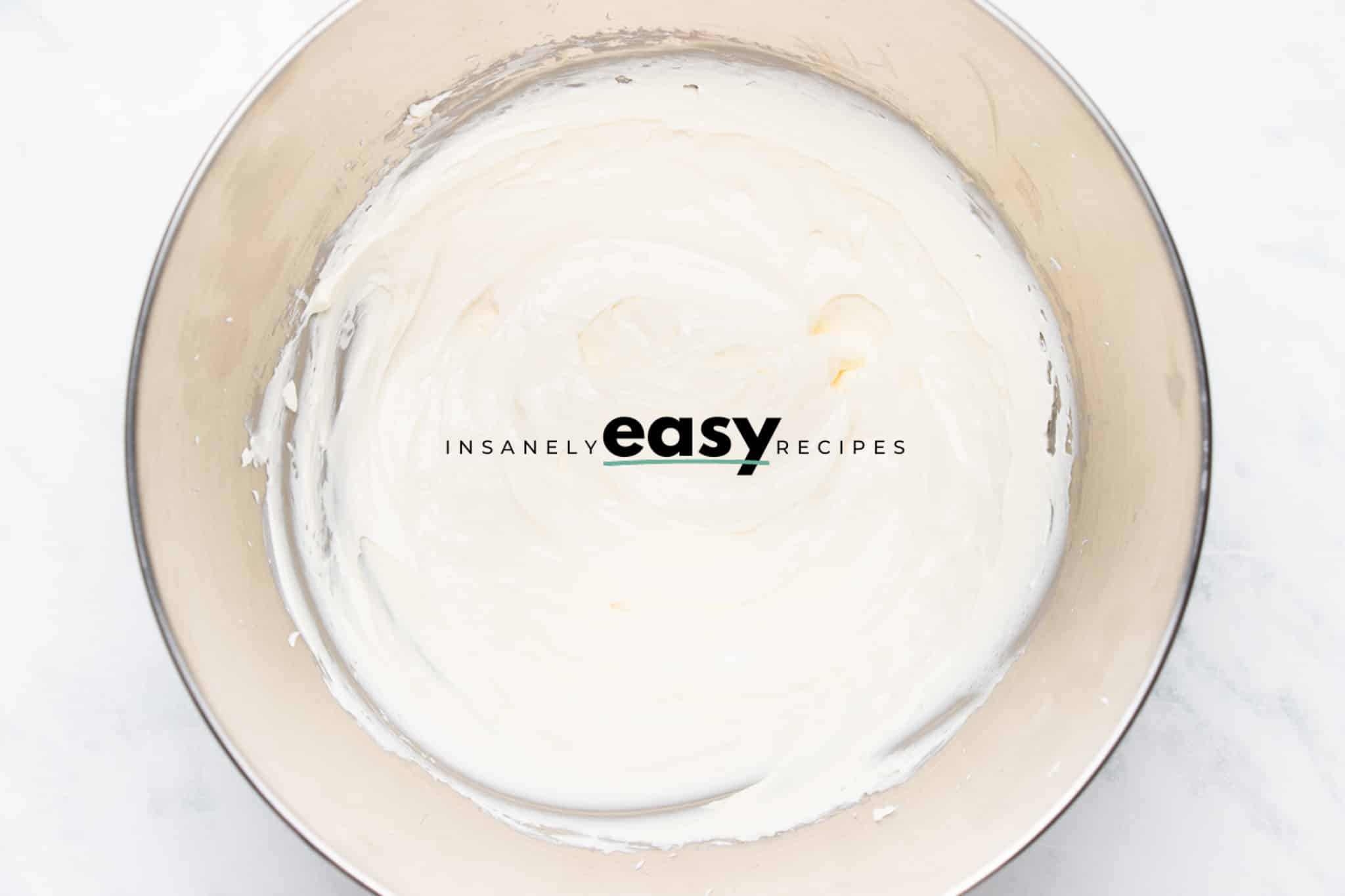 Top view photo of whipped cream cheese in white bowl.