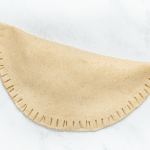 a folded fresh tortilla with the edges crimped with a fork.