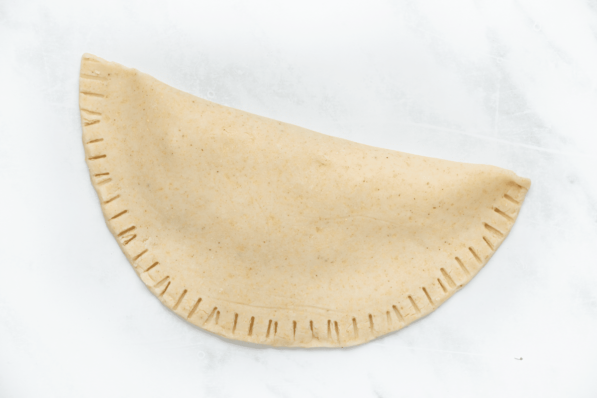 a folded fresh tortilla with the edges crimped with a fork.