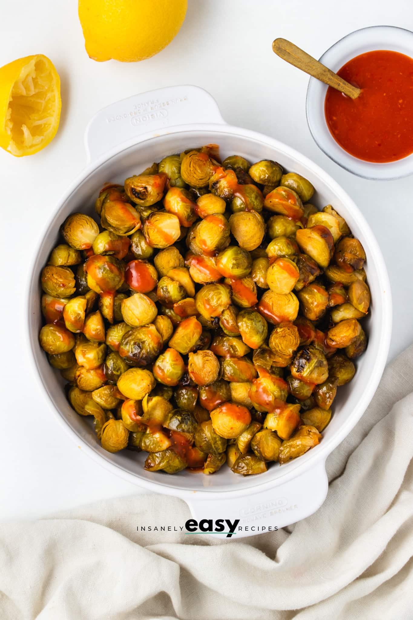 a bowl of roasted brussel sprouts with honey sriracha sauce.