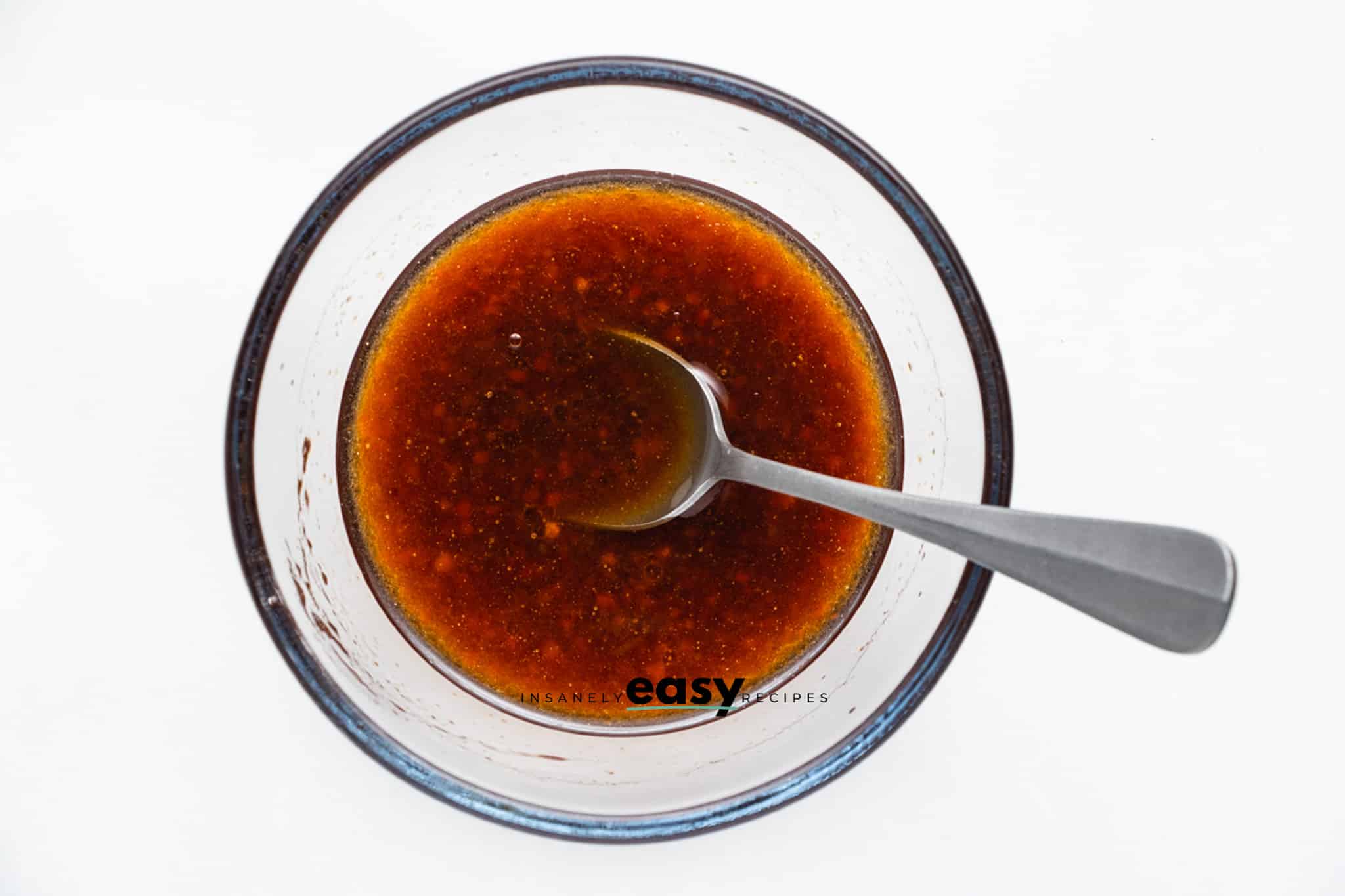 a small glass bowl with honey sriracha sauce in it.
