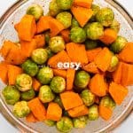 Top view photo of brussel sprouts and sweet potato chunks in a glass bowl, mixed together with oil and spices until completely covered.