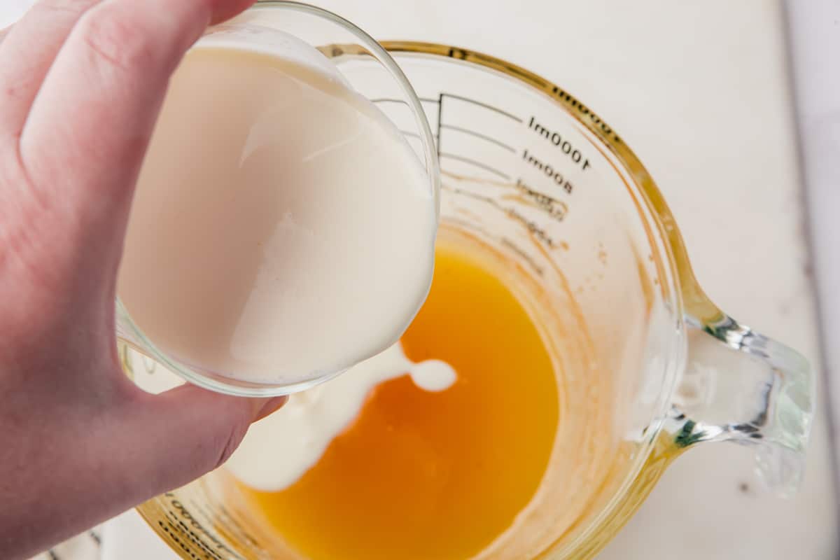 heavy cream being poured into caramel.