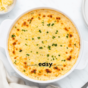 Top view photo of corn casserole with cream cheese in a white casserole dish.