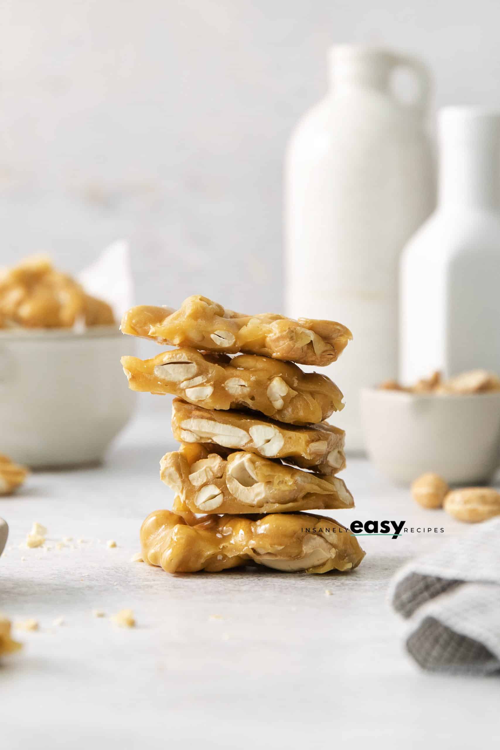 5 pieces of homemade cashew brittle, stacked on top of each other.