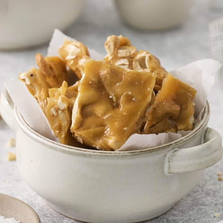 a ceramic crock filled with homemade salted cashew brittle