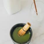 Photo of a small bowl with matcha powder and boiling water, mixed until fully combined.