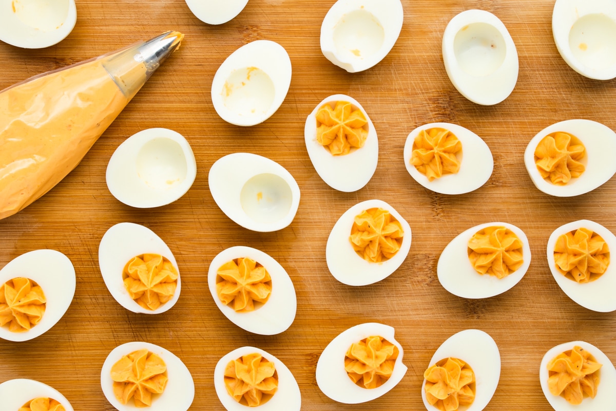 deviled eggs being filled with a piping bag