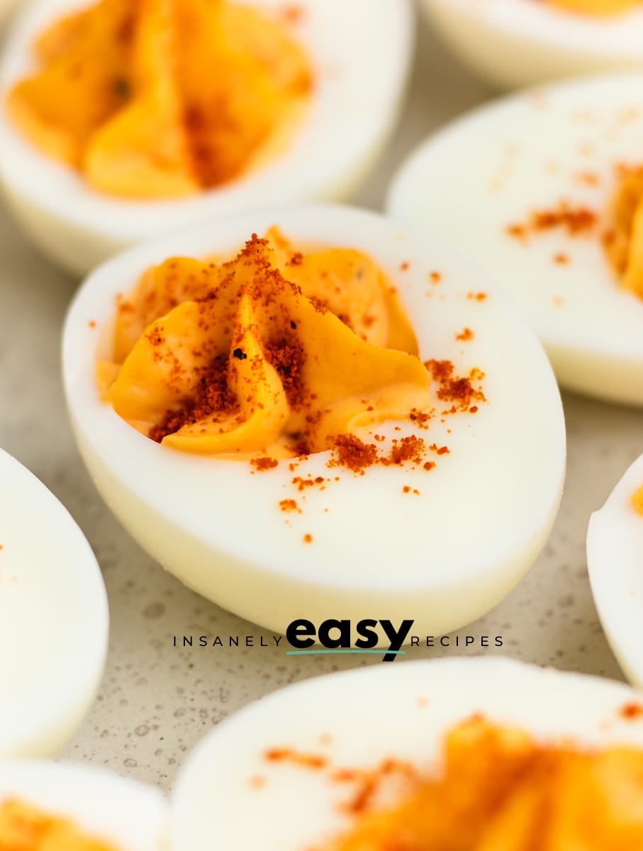 closeup of million dollar deviled eggs with star piped filling and paprika sprinkle.