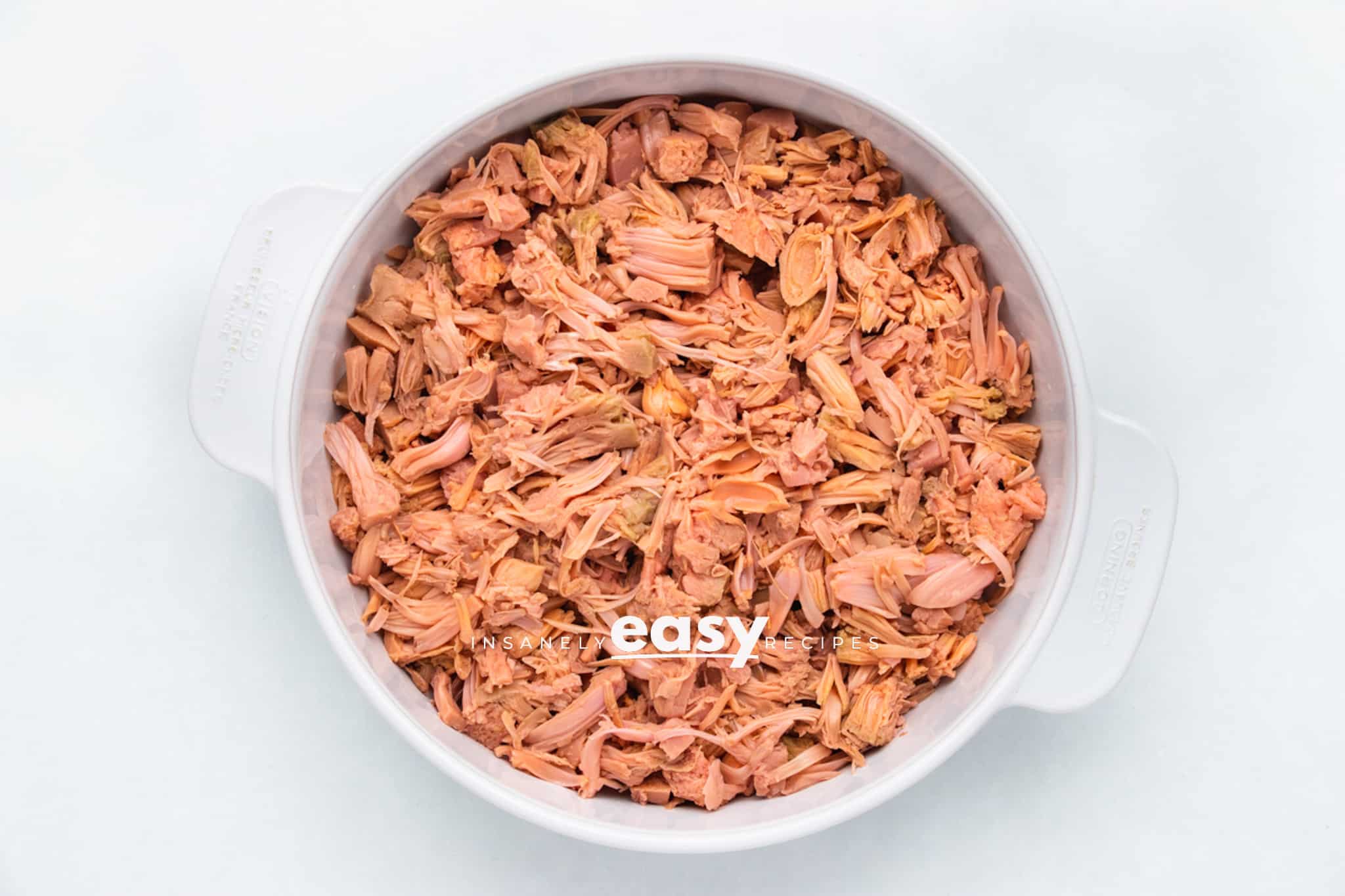 Photo of canned jackfruit that has been shredded, in a shallow white backing dip.